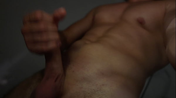 Un ragazzo muscoloso mostra il suo cazzo sotto la doccia