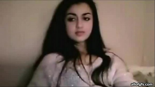 Bella donna indiana con lunghi capelli neri nella sua veste seduta su un letto